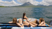 friends admiring the view of arenal volcano from the boat
 - Costa Rica