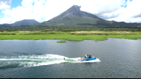 a wakesurfer follows the wake with a view of arenal volcano
 - Costa Rica