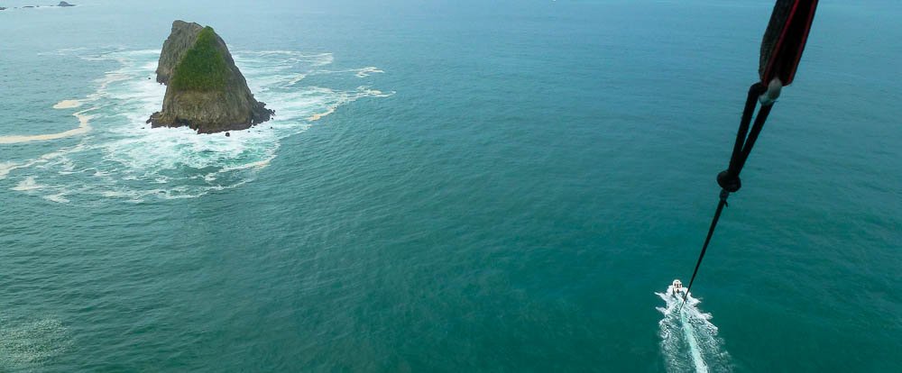 parasailing in the air 
 - Costa Rica