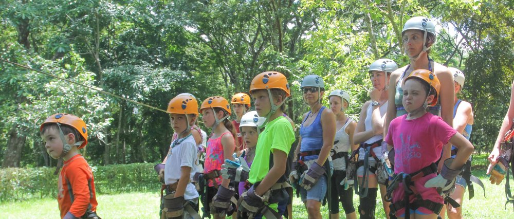 children listening to instructions to do canopy tour
 - Costa Rica