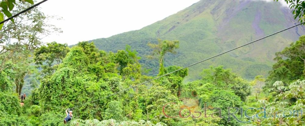 tree platform a person zooming and arenal volcano as background los canones canopy tour la fortuna
 - Costa Rica