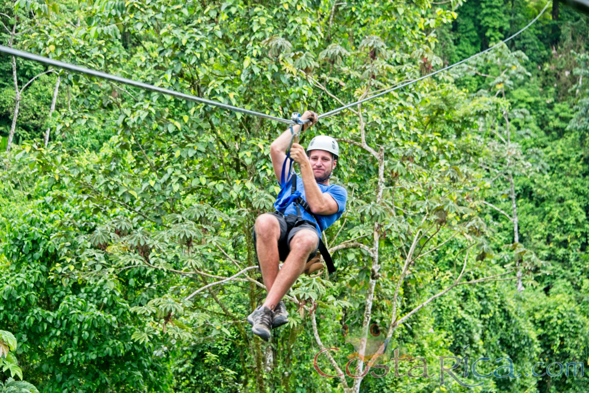 A Man Zip Lining Sitting Down Los Canones Canopy Tour La Fortuna