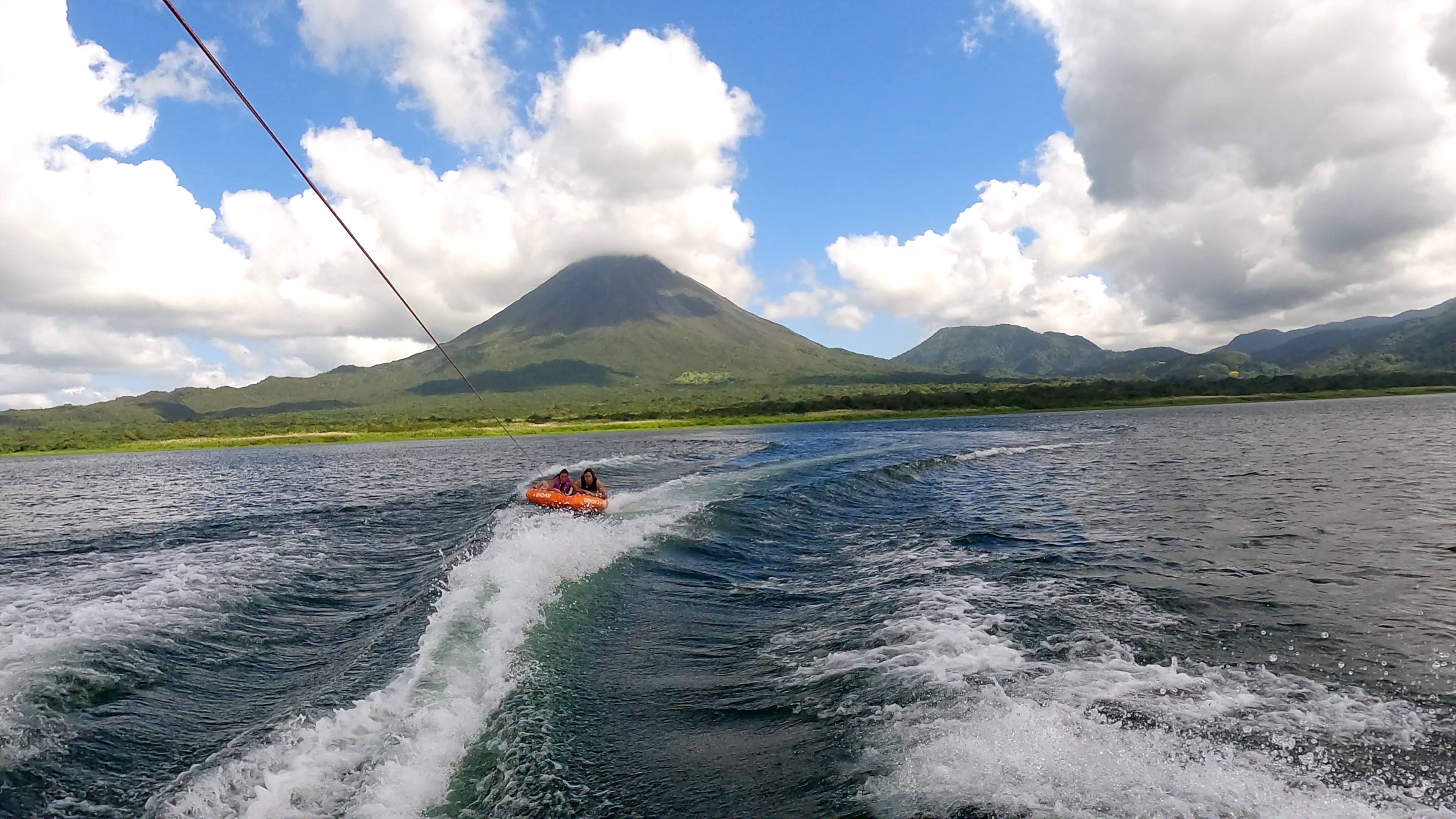 a couple of friends tubing on lake arenal with the view of the volcano.jpg