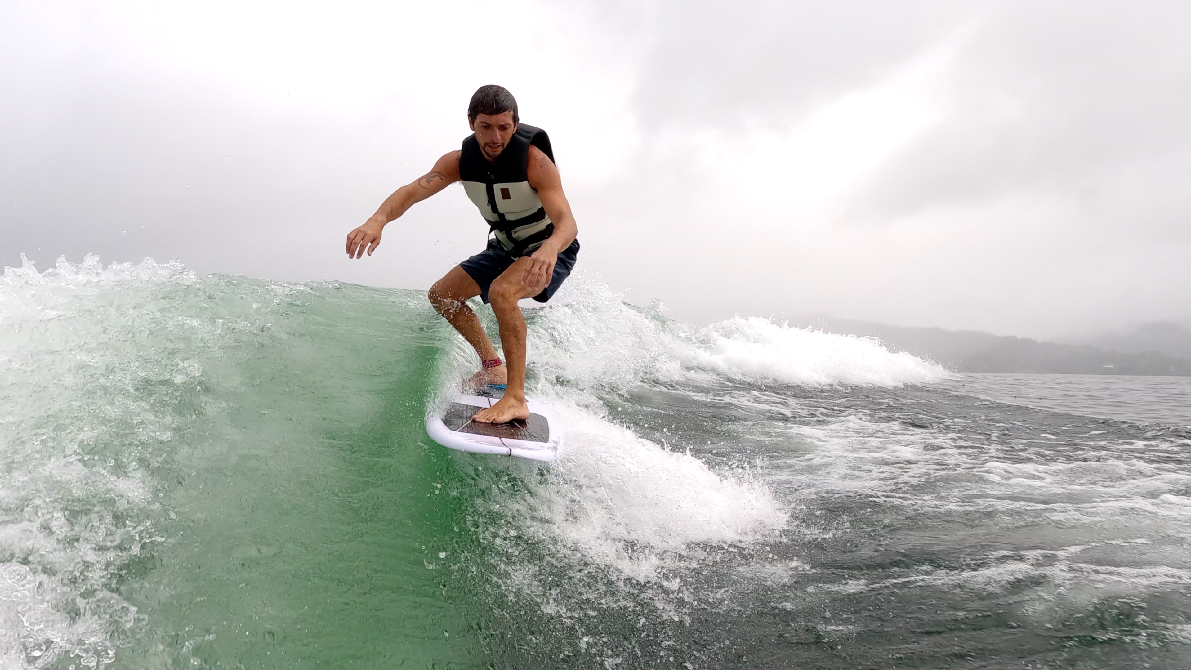 a man wakesufing on lake arenal in a rainy morning.jpg
