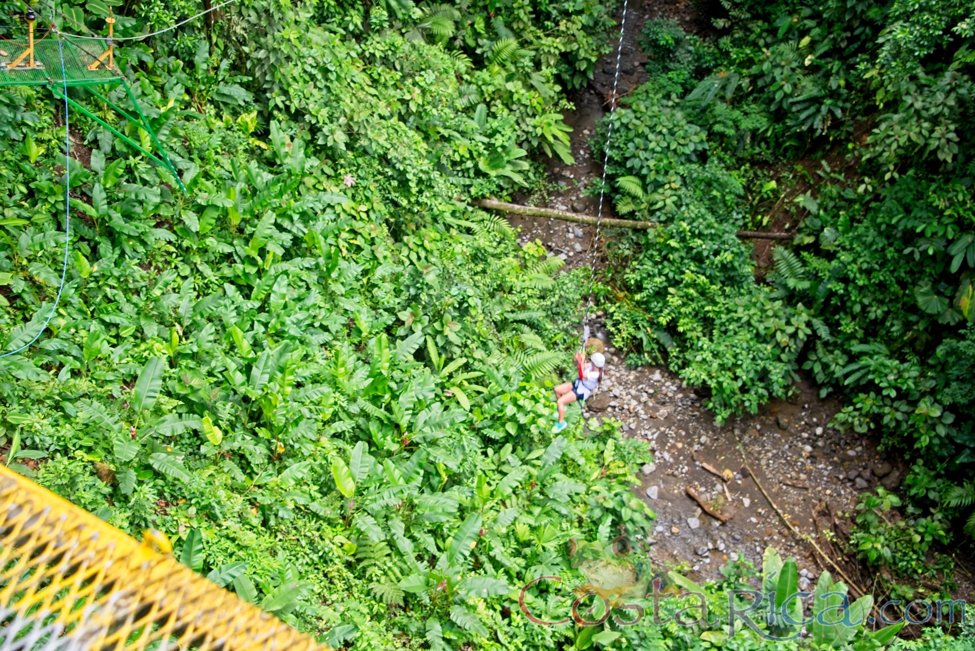 A Lady At The Bottom Of The Canyon In The Tarzan Swing Los Canones Canopy Tour La Fortuna