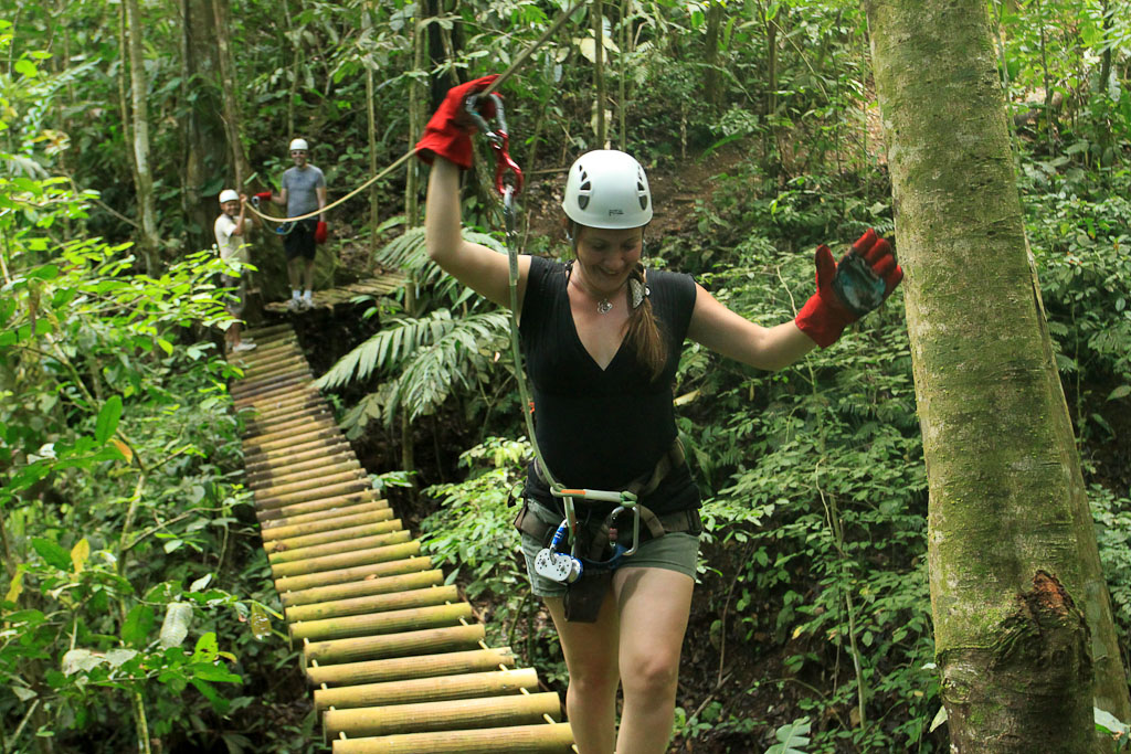 A visitor walks across the monkey bridge on the jungle adventure tour