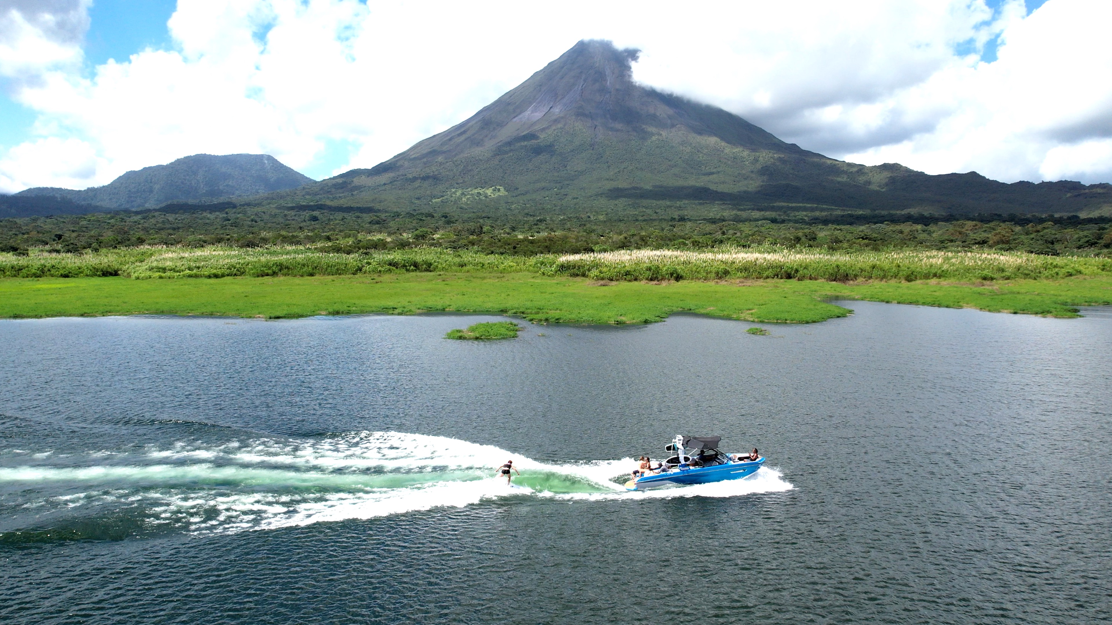 a wakesurfer follows the wake with a view of arenal volcano.jpg