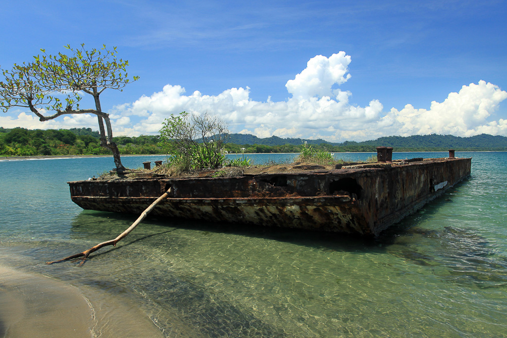 An old barge rusts in the salt water off the coast of Playa Negra