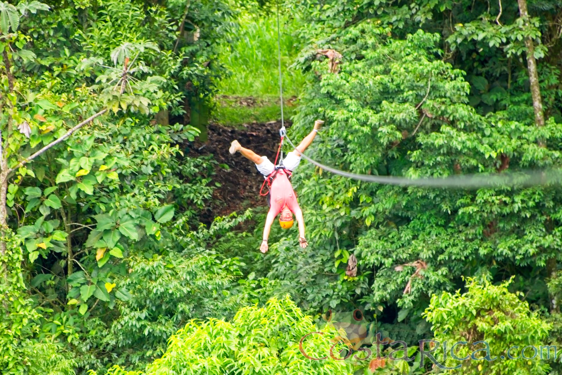 A Man Zip Lining Upside Down Los Canones Canopy Tour La Fortuna