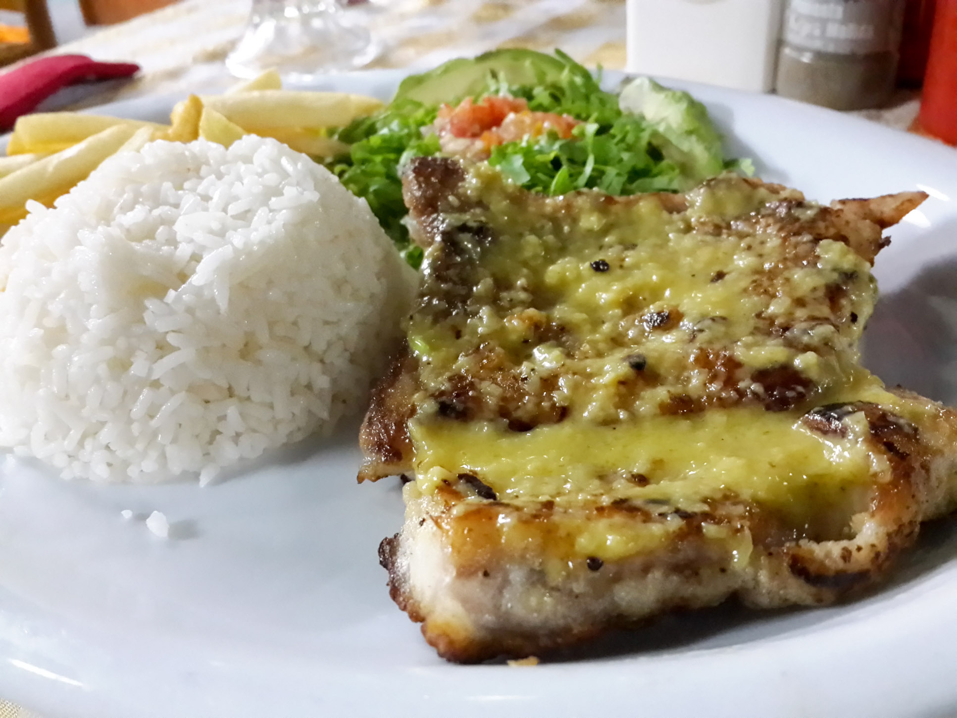 Grilled Fish Over Garlic Sauce At Perla Del Sur Restaurant